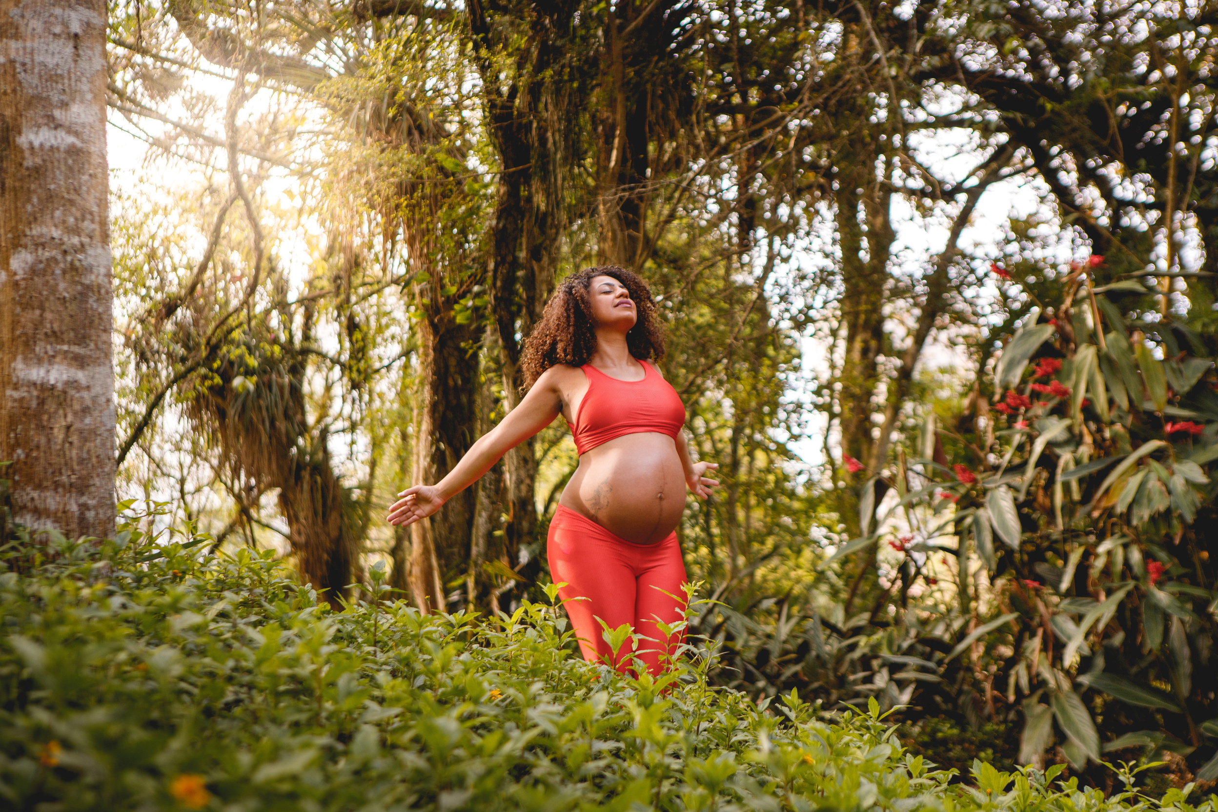 pregnant black woman doing yoga outdoors