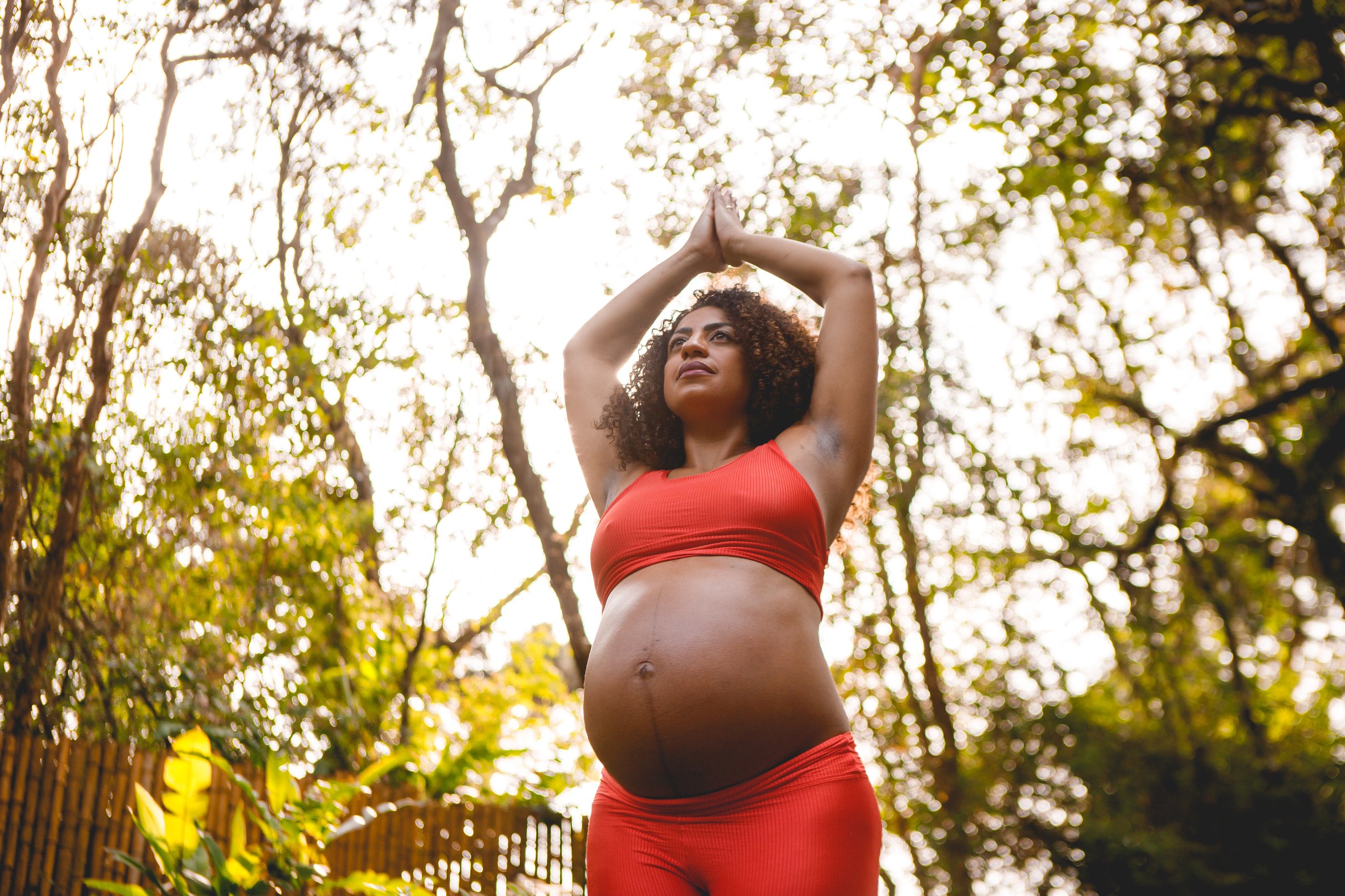 pregnant black woman doing yoga outdoors